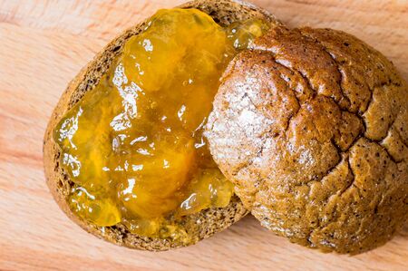 Bun with peach jam closeup view from above