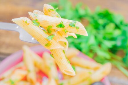 Fork with a few pasta penne on the backgroundの写真素材