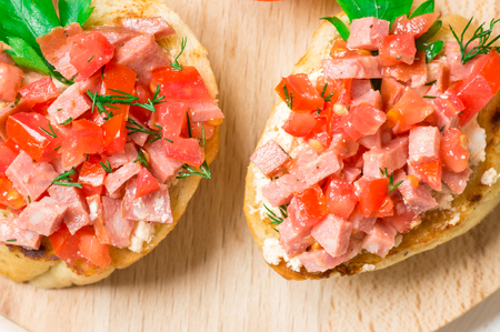 Tasty appetizer crostini (crostino) with tomato and sausageの写真素材