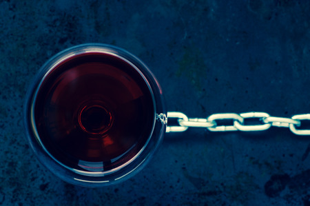 Glass of red wine with a steel chain top viewの写真素材
