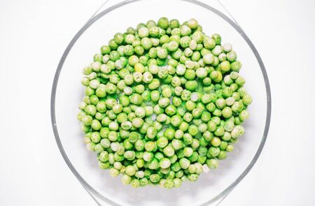 Green sweet peas defrost view from above on a white backgroundの写真素材