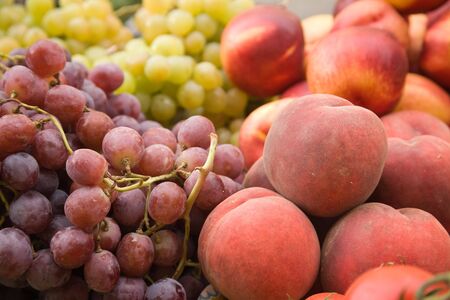 Grapes and peaches on a market stallの写真素材