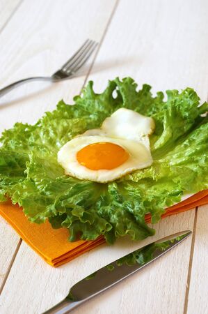 Fried egg and lettuce on a yellow napkinの写真素材