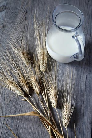 Jug of cold  milk and bred grainsの写真素材