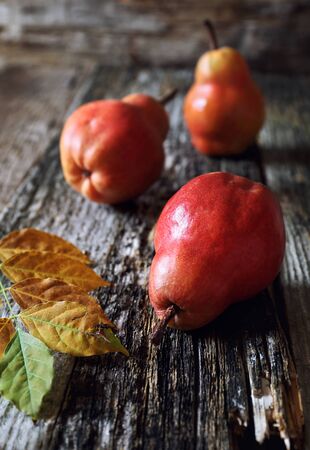 Three red autumn pears on old wooden background. Focus selectiveの写真素材