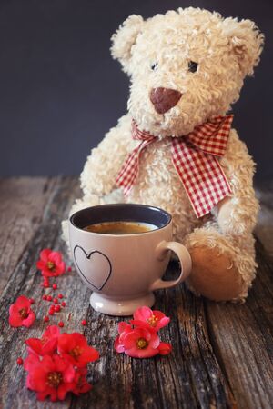 Teddy bear, spring flowers and cup of coffeeの写真素材