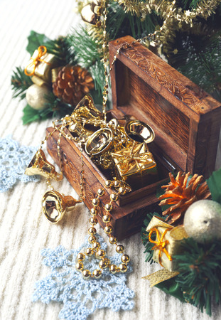 Christmas-tree decorations and goldish garland in carved wooden casket. Focus selective, toned imageの写真素材