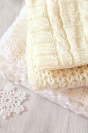 Preparation for winter: Pile of knitted white scarves. Toned imageの写真素材