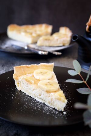 Banana coconut shavings tart on  black plateの写真素材