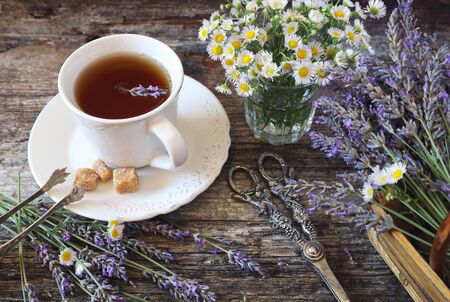Summer mood: ?romatic lavender tea, fresh lavander and wild chamomile, rustic style on old wooden backgroundの写真素材