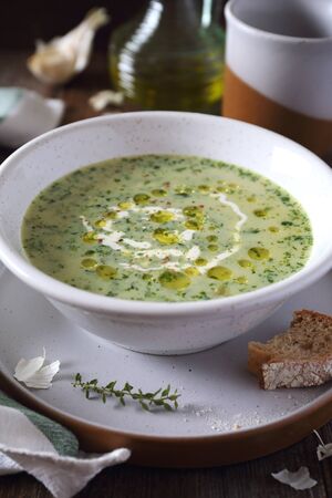 Spinach cream soup in ceramic plat, garlic and olive oil. Rustic styleの写真素材
