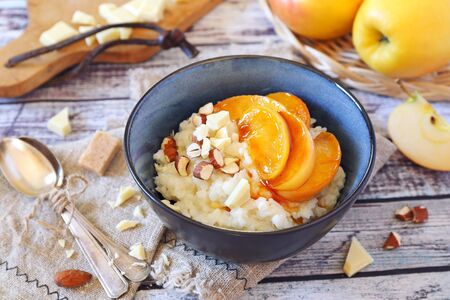 Dairy homemade rice pudding with almond nuts, milk chocolate and caramelized apples for nice breakfastの写真素材