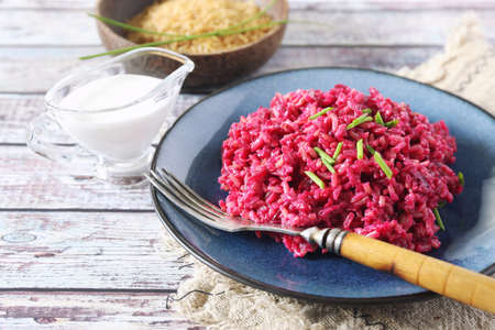 Diet food. Pink rice. Beetroot risotto from brown rice with almond milk, chives onion dressingの写真素材