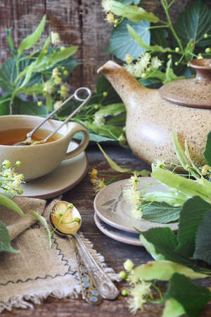 Cup of herbal tea with linden flowers on old wooden backgroundの写真素材