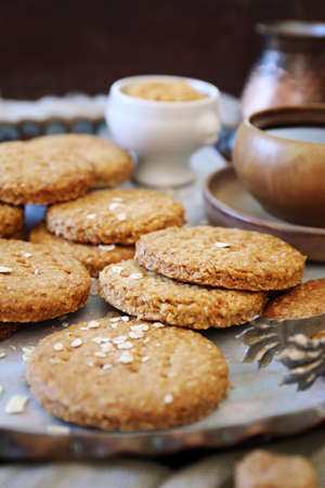 Crispy oatmeal cookies, cezve and cup of coffee for coffee break on wooden background