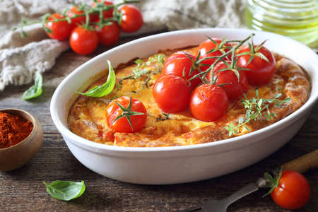 french cuisine. Cherry tomatoes clafoutis (or flan) in ceramic bakeware, rustic style on wooden backgroundの写真素材