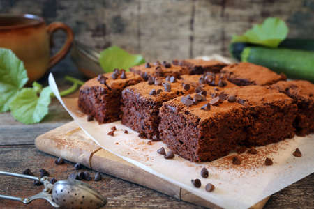 Chocolate Zucchini brownie with chocolate chips, cocoa powder dressing on wooden backgroundの写真素材