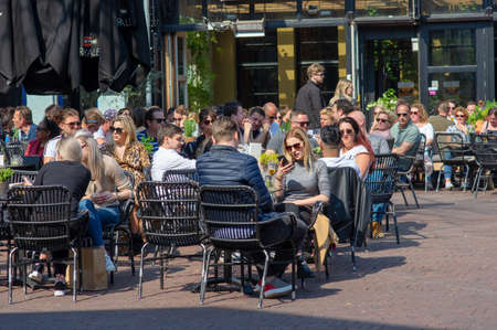 Arnhem, Netherlands - April 7, 2019: People relax and enjoy a drink at an outdoor cafe terrace at the Korenmarkt.のeditorial素材