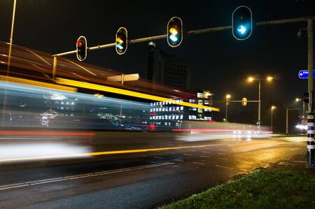 Intersection at night with traffic lights and traffic blurred by motion in Arnhem, Netherlands