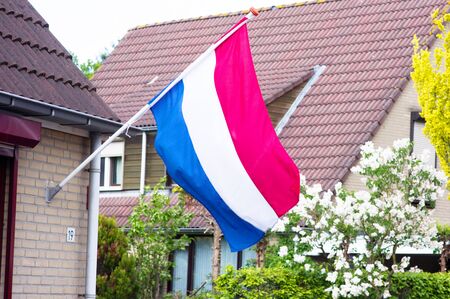 Dutch flag on a facade of a house during a national holiday in the Netherlands
