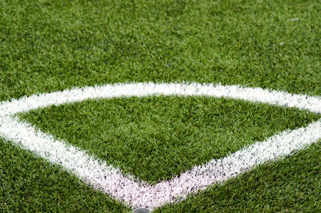 White border stripes on green artificial grass of a football field