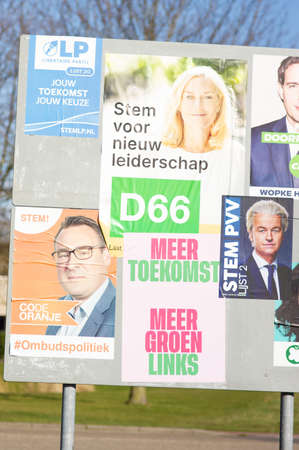 Elst, Netherlands - February 24, 2021: Billboard with dutch political campaign posters for the Dutch House of Representatives elections in march 2021.のeditorial素材