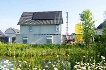 House under construction with a black roof with solar panelsのeditorial素材