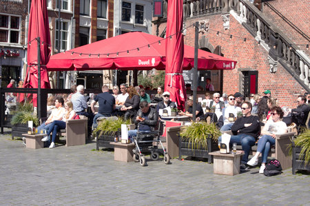 Nijmegen, Netherlands - April 16, 2022: People relax and enjoy a drink at an outdoor cafe terrace in the center of Nijmegenのeditorial素材
