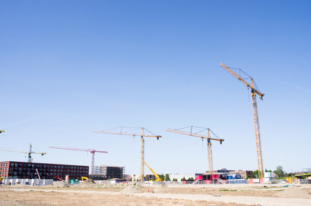 Nijmegen, Netherlands - May 8, 2022: Buildings under construction with large cranes on top with a clear blue skyのeditorial素材