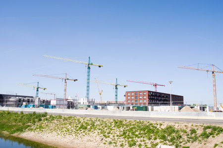 Nijmegen, Netherlands - May 8, 2022: Buildings under construction with large cranes on top with a clear blue skyのeditorial素材