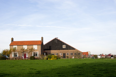 Dutch farm with a larger barn and a green meadow in the foreground in Arnhem in the Netherlandsのeditorial素材