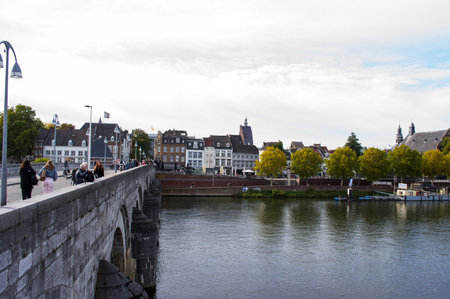 Maastricht, Netherlands - October 12, 2022: Cityscape of the center of Maastricht with in the foreground people walking on a bridge over the river Meuseのeditorial素材
