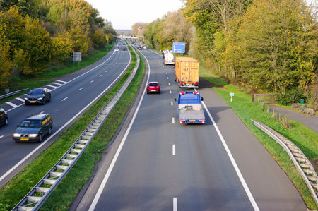 Arnhem, Netherlands - November 11, 2022: Busy highway with trucks and cars in the foreground