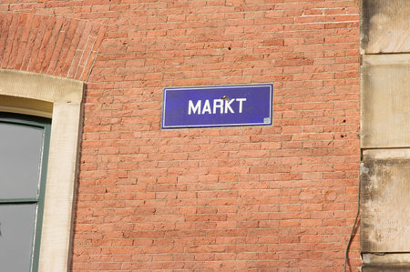 Blue street name sign of Markt on a brick stone wall in Arnhem in the Netherlandsの写真素材