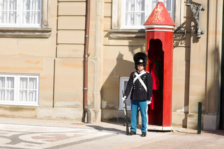 Copenhagen, Denmark - April 8, 2023: Royal guard in traditional uniform in front of a red sentry box at Amalienborg palace in Copenhagen, Denmarkのeditorial素材