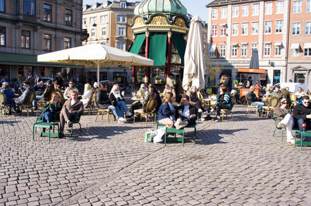 Copenhagen, Denmark - April 6, 2023: People relax and enjoy a drink at an outdoor cafe terrace in the center of Copenhagenのeditorial素材