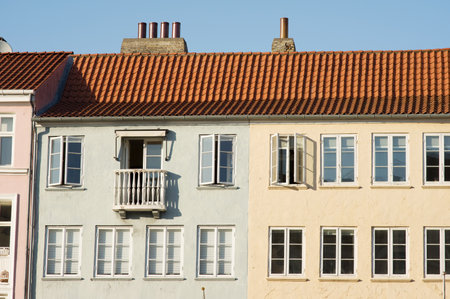 Green and yellow historic terraced houses in Nyhavn in the center of Copenhagen in Denmarkのeditorial素材