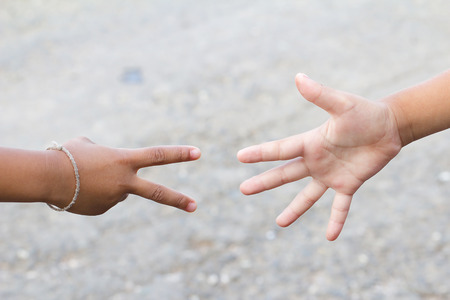 Children's hands playing, paper and scissors game.の写真素材