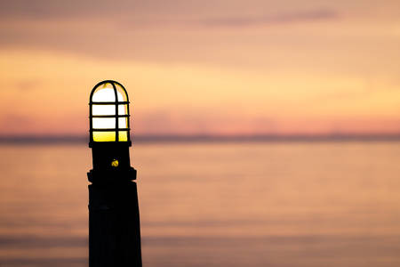 Lamps on the background sea.Lighting on the wooden bridge.   style silhouette on the background blurred nature sunsets.の写真素材