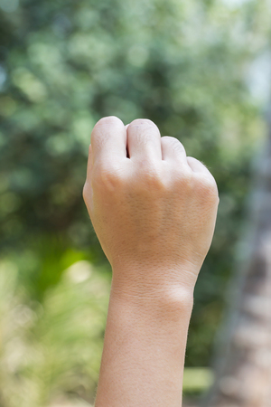 Fists hand lifted up outdoors on natural background blurred.zeroの写真素材