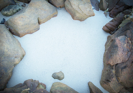 Gaps of sandy beach With rocks surrounding and a space for text.の写真素材