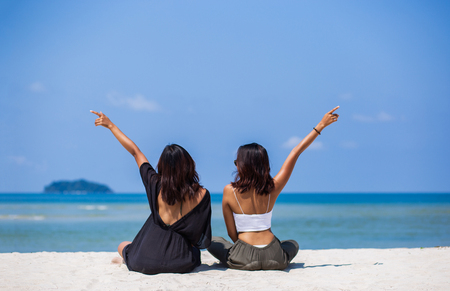 Two young women relaxing seats in the ocean. During the summerの写真素材