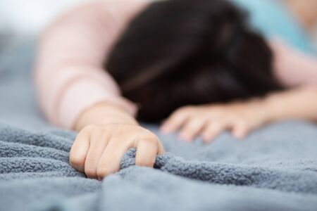 The woman's hand on the white bed, the woman's hand pulled the white sheets in ecstasy, feelings and emotions.の写真素材