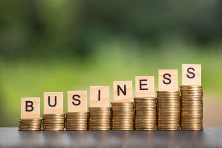 business and pile of coins on abstract style blurred nature backgroundの写真素材