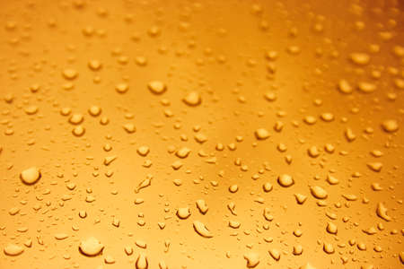 Warm orange water drops over glass backgroundの写真素材