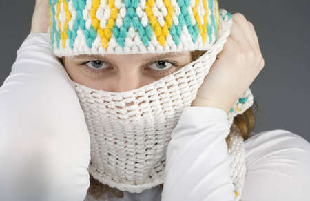 Woman in warm clothing with scarf wraped around the face looking at cameraの写真素材