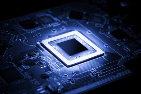 Glowing modern processor. Big illuminated graphic processor surrounding by other electrical components. Special tone image. Low aperture shot, focus on lower part of chip.の写真素材