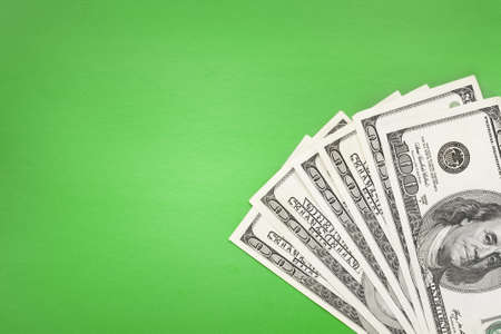 100  banknotes lying in corner on green simple background の写真素材