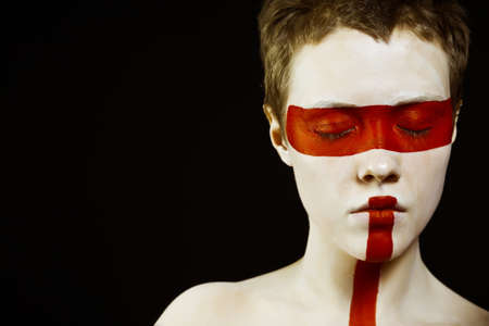 Close-up portrait of young woman with painted face  Focus on eyes, empty spaceの写真素材