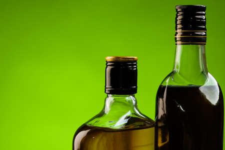 Two bottles of alcohol drinks on green backgroundの写真素材
